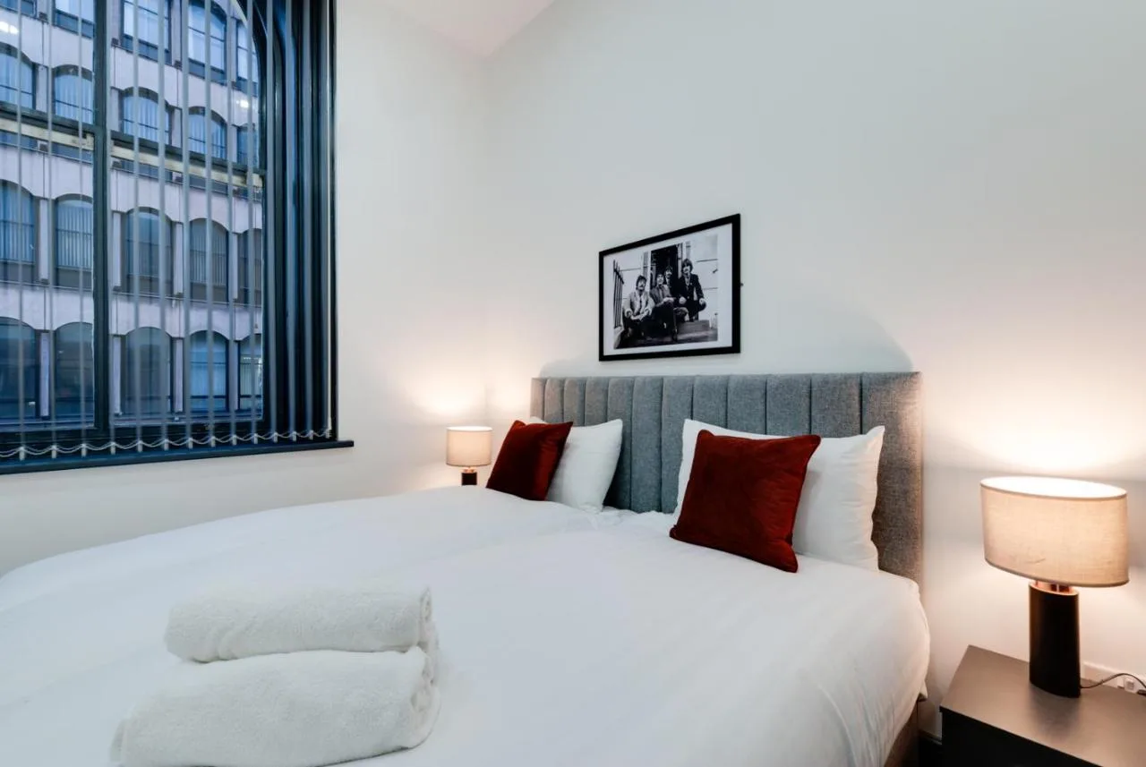 a bedroom with a white bed and a large window at Harrisons Aparthotel Liverpool in Liverpool