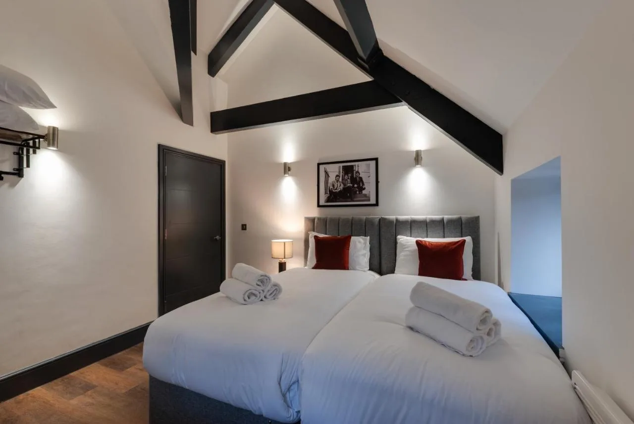 a bedroom with a large white bed with red pillows at Harrisons Aparthotel Liverpool in Liverpool