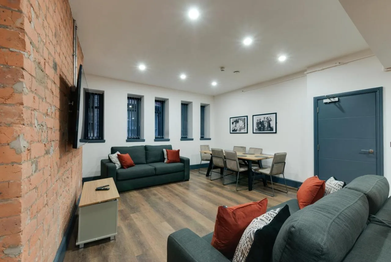 a living room with couches and a brick wall at Harrisons Aparthotel Liverpool in Liverpool